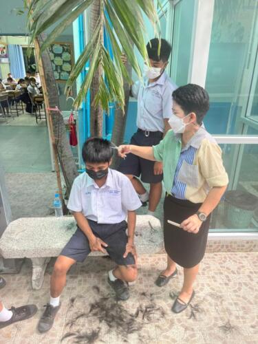 คุณครูร่วมกันจัดระเบียบทรงผมนักเรียน